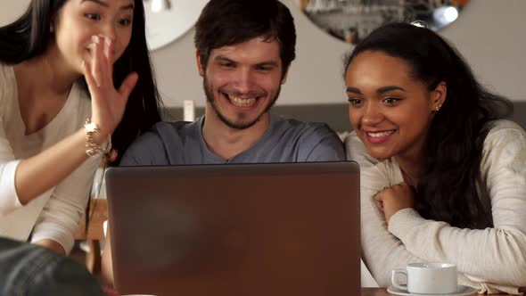 Young People Wave Their Hands To the Laptop Screen at the Cafe