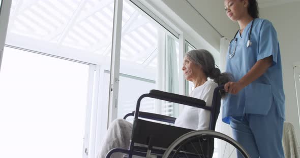 Mature woman in a wheelchair and nurse