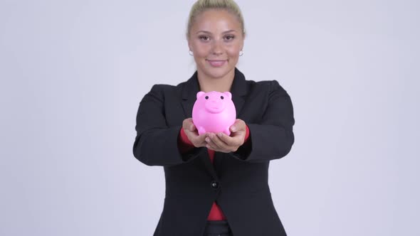 Young Happy Blonde Businesswoman Giving Piggy Bank