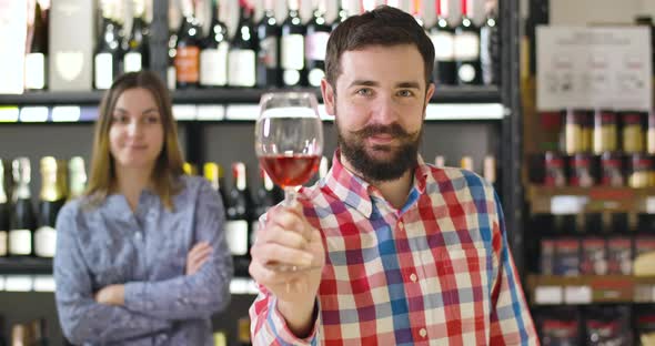 Happy Smiling Caucasian Man Smelling Red Wine, Stretching Glass To Camera, and Drinking Alcohol