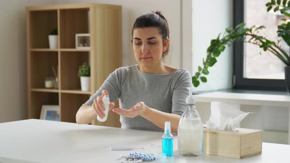 Woman Spraying Hand Sanitizer at Home