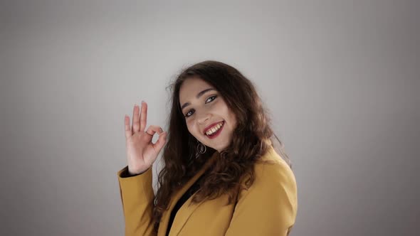 Woman is Showing Ok Sign and Waving Hand for Saying Goodbye in Slowmo on a White Background