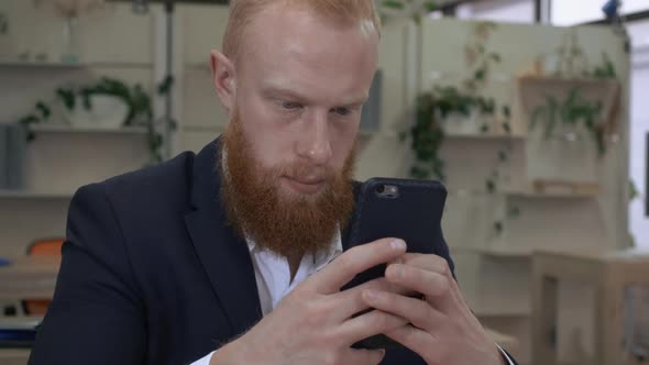 Redhead Businessman Texting on Cellular