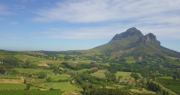 Wide shot of Simonsberg mountain with farmland below.