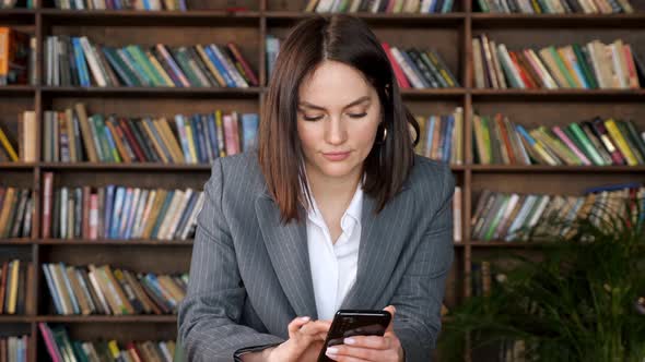 Stylish Businesswoman in Jacket Types on Black Smartphone