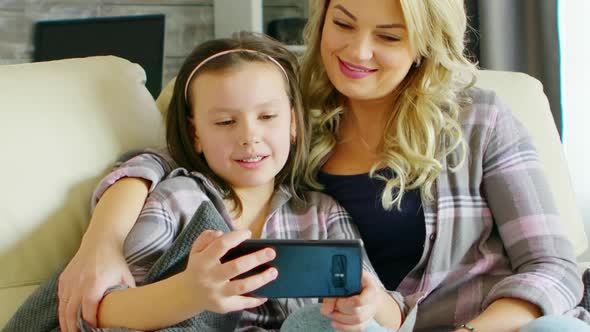 Beautiful Young Mother and Her Daughter Laughing