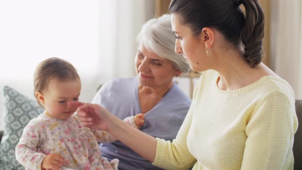 Mother, Daughter and Grandmother on Sofa at Home