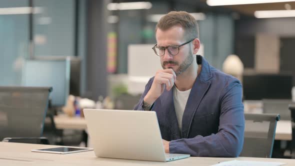 Middle Aged Businessman Talking on Video Call on Laptop in Office