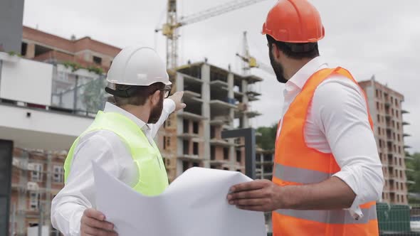 Male Construction Engineer Discussion with Architect at Construction Site or Building Site 