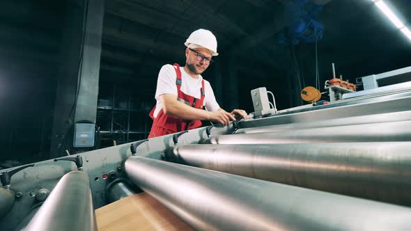 Metallurgy Worker Is Adjusting the Rolling Conveyor