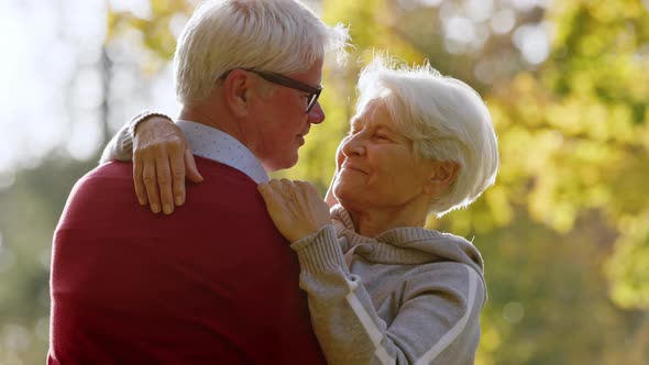 Loving Hug Between Elderly Retired Caucasian Man and Woman in the Park