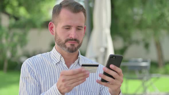 Outdoor Portrait of Middle Aged Man Making Online Payment on Smartphone
