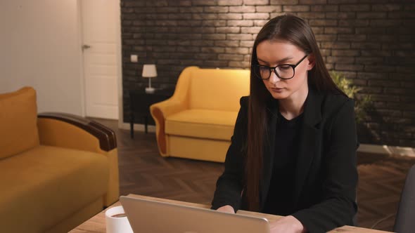 Tired Pretty Caucasian Businesswoman in Glasses Typing on Laptop Working at Home Office