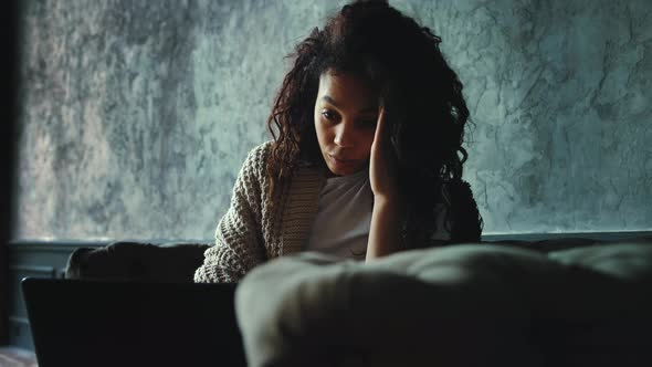 Portrait of Young African American Woman Feeling Disappointed Reading News Using Laptop at Home