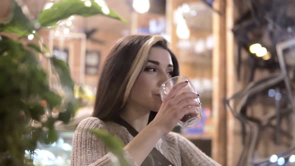 Beautiful Girl Drinking Cacao or Coffee in Cafe