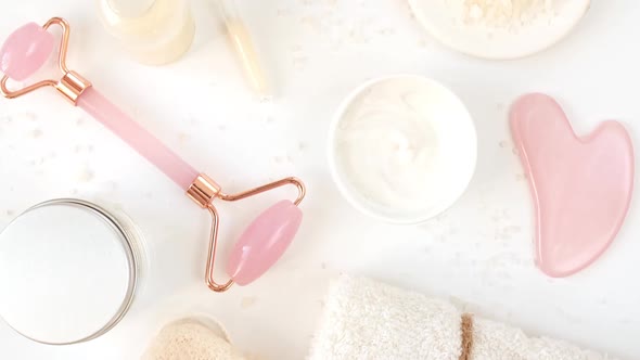 Rotation of Pink Quartz Facial Roller and Glass Bottle with Pipette with Gel Fluid Collagen Serum