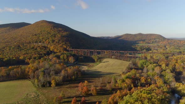 Aerial of rail road bridge and autumn forest on Hudson Valley