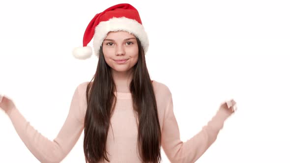 Horizontal Portrait of Cheerful Female with Very Long Dark Hair Touching Santa Claus Red Hat on Head