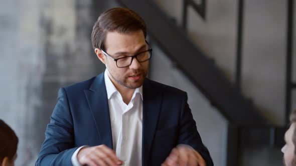 Serious man in suit explaining office work during sanctions period