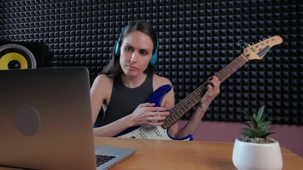 Female Learning Play Guitar at Home Using Online Lessons