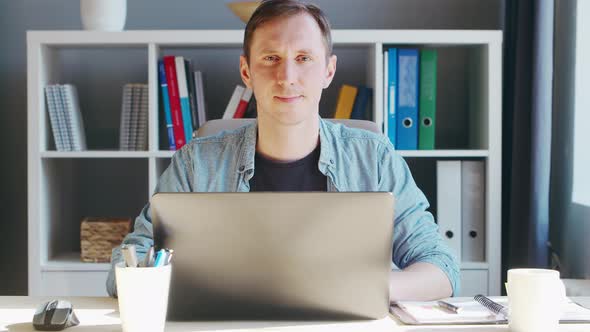 Young male entrepreneur works at home office at the computer.