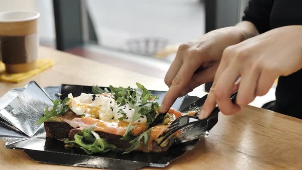 Person Hands Cut Bread with Salmon Egg with Knife and Fork