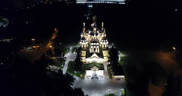 Bright Church with Golden Domes and Crosses. Glows in The Night Park. Drone Footage