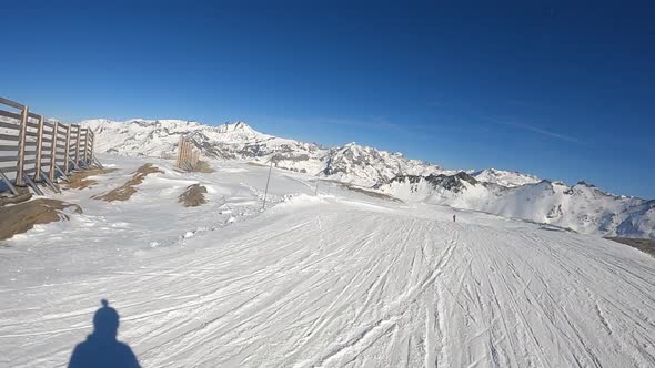 A Snowboarder Descends at Speed From a Mountainside in the Alps