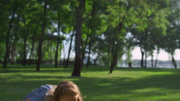 Joyful Girl Hitting Shuttlecock Toss with Racket in Golden Sunlight Park