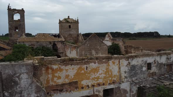 Aerial drone fly over abandoned ruined destroyed farmhouse building in a field, Spain