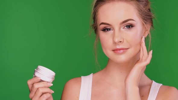 Female Applies Face Cream and Laughs To the Camera