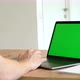 Close-up of a Man Uses Laptop with Green Mock-up Screen While Sitting at the Desk - VideoHive Item for Sale