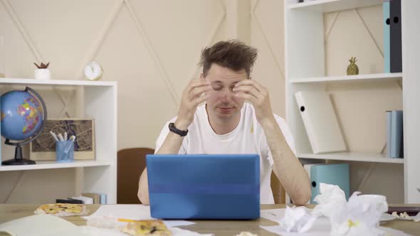 Stressed Brunette Caucasian Man Holding Head with Hands and Sighing