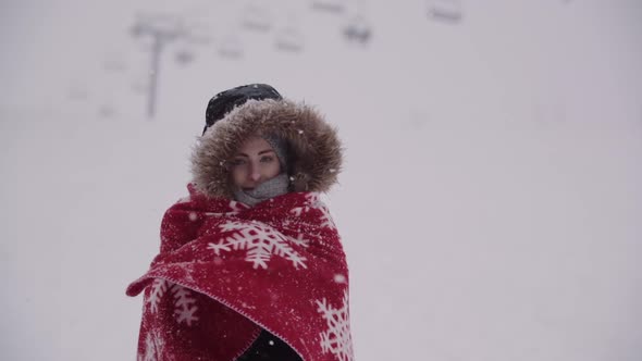 Close Up of Frozen Woman Wrapped in a Blanket at Snowstorm