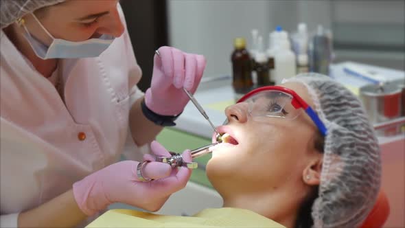 Female Professional Dentist at Work, Makes Anesthesia To a Patient Before Tooth Treatment. Dental