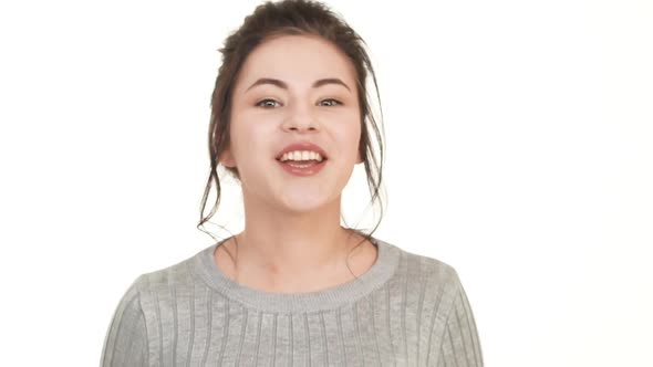 Very Happy Caucasian Brunette Teenager Girl Standing on White Background and Happily Smiling