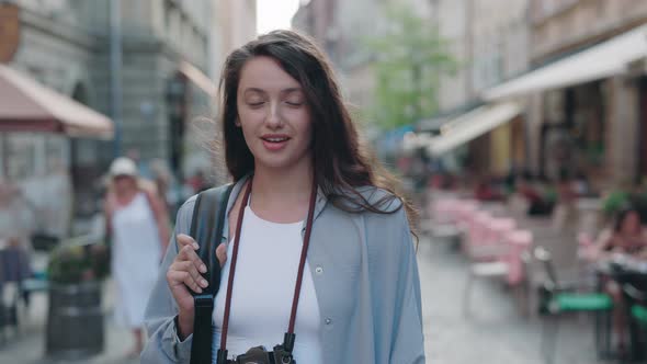 Charming Caucasian Woman Standing with Backpack on Street