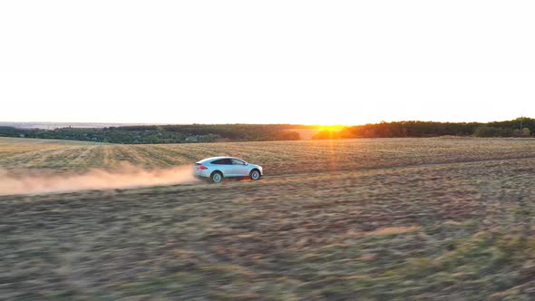 Aerial Shot of Electrical Car Speeding Through Dusty Route