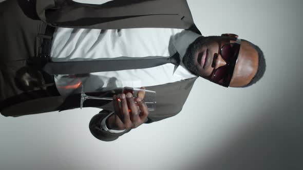 Fashionable Black Man Posing with Wine in Studio