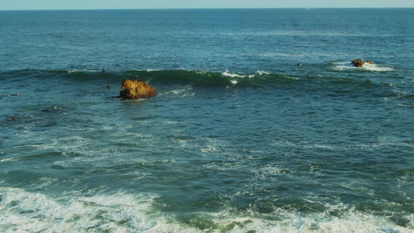 Surfers catching waves and riding their boards off the coast of California.