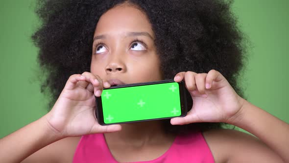 Young Cute African Girl with Afro Hair Showing Phone While Thinking