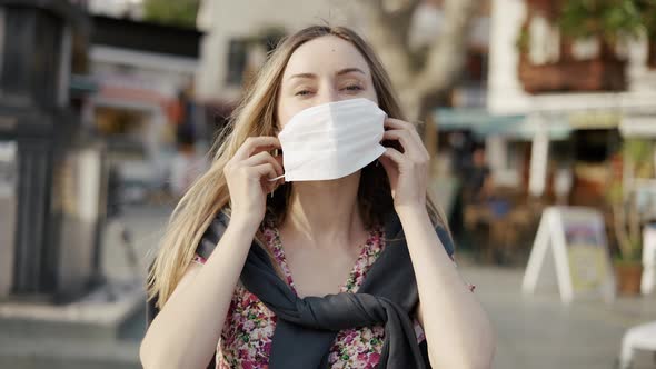 Blonde Woman Putting on Medical Mask on Crowdy Street