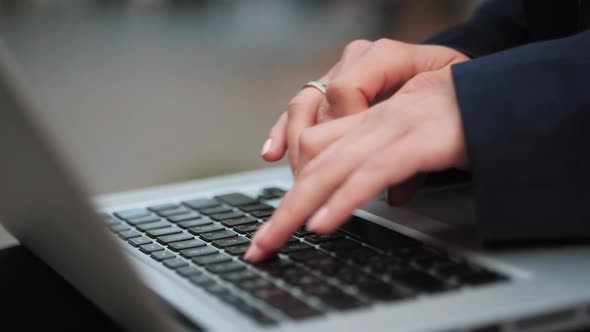 Female Hands Working on Laptop in the Street, Urban Scene, Camera Stabilizer Shot. Slow Motion.