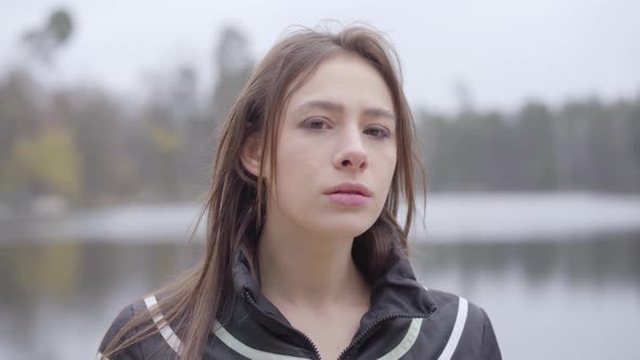 Young Beautiful Caucasian Woman Turning To Camera and Putting on Black Protective Face Mask