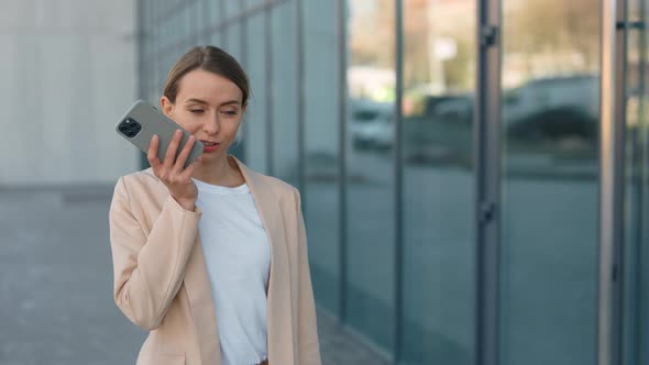 Woman Recording Voice Message on Smartphone Outdoors