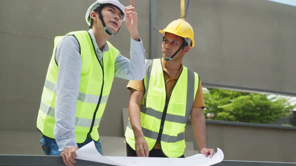 Medium shot of Asian foreman engineer and construction builder worker work onsite of architecture.