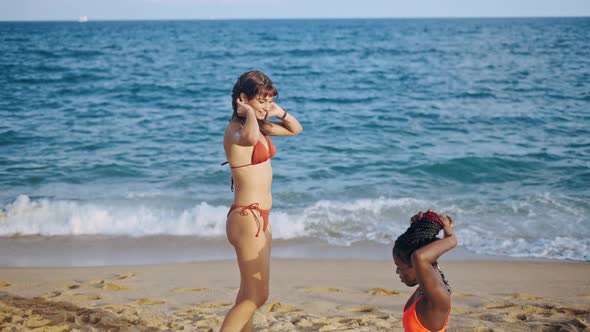 Two Young Women of Different Races on Summer Seashore