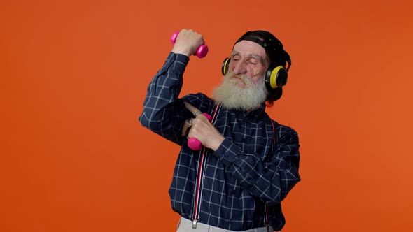 Elderly Bearded Man Listening Music Via Headphones Working Out Lifting Pink Dumbbells Healthcare