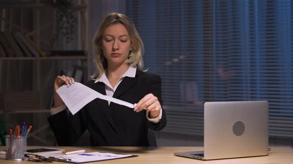 Businesswoman Holds Contract in Hands and Ripping It Apart