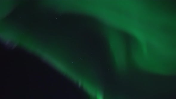 The northern lights filmed in real time over mountain landscape on the island Kvaløya near Tromsø in